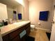 Full bathroom features a single sink vanity, tiled floors, tub/shower and decorative hand towels at 208 Oleander St, Winter Haven, FL 33881