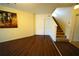 Open entryway with hardwood floors leading to carpeted stairs, offering a welcoming transition in the home at 208 Oleander St, Winter Haven, FL 33881
