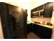 Compact kitchen featuring black appliances and cabinets, maximizing space with functional design at 208 Oleander St, Winter Haven, FL 33881