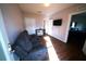 Cozy living room with a comfortable couch, small table, mounted television, and dark wood floors at 208 Oleander St, Winter Haven, FL 33881