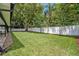 Expansive backyard with lush green grass, mature trees, and a white fence for privacy at 2112 Fosgate Dr, Winter Park, FL 32789