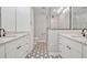 Modern bathroom with dual sinks, marble countertops, hexagon floors, and a glass-enclosed shower at 2112 Fosgate Dr, Winter Park, FL 32789