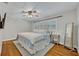 Bedroom with hardwood floors and plantation shutters features a bed with a blue comforter at 2112 Fosgate Dr, Winter Park, FL 32789