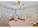 Cozy Bedroom with hardwood floors, chair, ottoman, plantation shutters, and a crib at 2112 Fosgate Dr, Winter Park, FL 32789