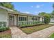 Charming home entrance features a brick walkway, manicured bushes, and covered porch at 2112 Fosgate Dr, Winter Park, FL 32789