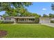 Charming brick home featuring a two-car garage, lush green lawn, and decorative landscaping at 2112 Fosgate Dr, Winter Park, FL 32789
