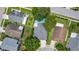 An overhead shot reveals a house nestled among trees, featuring a backyard pool and a well-manicured lawn at 222 Imperial Ridge Ct, Oviedo, FL 32765