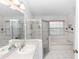 Bright bathroom featuring tiled floor, tub, separate glass enclosed shower and sink with cabinets at 222 Imperial Ridge Ct, Oviedo, FL 32765