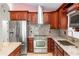 Modern kitchen with stainless steel appliances, granite countertops, and cherry wood cabinets at 222 Imperial Ridge Ct, Oviedo, FL 32765