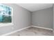 Bedroom boasts a large window, light-colored wood-look tile floors, and neutral paint at 23430 Sw Neptune Blvd, Dunnellon, FL 34431