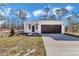 Charming single-story home with a well-manicured lawn, a dark brown garage door and inviting front entrance at 23430 Sw Neptune Blvd, Dunnellon, FL 34431