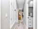 Long hallway showcases light-colored wood-look tile floors and leads to a full bathroom at 23430 Sw Neptune Blvd, Dunnellon, FL 34431
