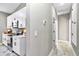 Well-lit kitchen with white cabinets and stainless steel appliances, adjacent to a hallway at 23430 Sw Neptune Blvd, Dunnellon, FL 34431