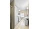 Bright bathroom features a white vanity, toilet, and washer and dryer in an all-in-one space at 244 N Leavitt Ave, Orange City, FL 32763