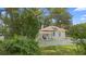 Quaint home with a lovely front porch, enveloped by lush greenery and mature trees at 244 N Leavitt Ave, Orange City, FL 32763