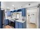 Bright, cozy kitchen featuring blue cabinetry, white countertops, and stainless steel appliances at 244 N Leavitt Ave, Orange City, FL 32763