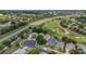 Aerial view of homes backing onto a golf course with mature trees and a nearby highway at 2500 Castle Pines St, Clermont, FL 34711