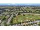 Aerial view showcasing homes near a golf course with mature trees and a highway at 2500 Castle Pines St, Clermont, FL 34711