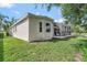 Home exterior featuring a screened-in porch, well-maintained lawn, and mature trees at 2500 Castle Pines St, Clermont, FL 34711