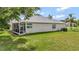 The backyard features lush green grass and a screened-in porch, perfect for enjoying the outdoors at 2500 Castle Pines St, Clermont, FL 34711