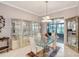 Elegant dining room with a glass table, white chairs, and stylish glass cabinets at 2500 Castle Pines St, Clermont, FL 34711