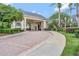 Circular brick driveway leading to a grand entrance with columns and lush landscaping at 2500 Castle Pines St, Clermont, FL 34711