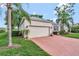 Charming home featuring a brick driveway, well-manicured lawn, and a two-car garage at 2500 Castle Pines St, Clermont, FL 34711