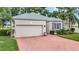 Charming one story home with brick driveway, manicured landscaping, and a two car garage at 2500 Castle Pines St, Clermont, FL 34711