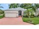 Charming home with a brick driveway, well-manicured lawn, and a two-car garage at 2500 Castle Pines St, Clermont, FL 34711
