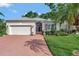 Charming single-story home with a brick driveway, well-manicured lawn, and beautiful landscaping at 2500 Castle Pines St, Clermont, FL 34711