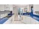 Charming kitchen with white cabinetry, blue countertops, and stainless steel appliances at 2500 Castle Pines St, Clermont, FL 34711