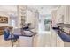 Bright kitchen featuring white cabinets, blue countertops, and open access to the living areas at 2500 Castle Pines St, Clermont, FL 34711