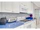 Well-equipped kitchen with modern appliances, white cabinets, and blue countertops at 2500 Castle Pines St, Clermont, FL 34711