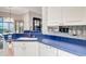 Bright kitchen with white cabinets, blue counters, and stylish wine glass rack at 2500 Castle Pines St, Clermont, FL 34711