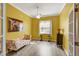Bright yellow office features a sofa, wood-look floors, and white trim at 2500 Castle Pines St, Clermont, FL 34711