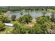 Expansive aerial shot showcases a picturesque lakefront property, lush trees, and charming home at 2990 E Central Ave, Bartow, FL 33830