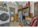 Cluttered laundry room with washer and dryer, shelves, and various household items stored on the floor and shelves at 2990 E Central Ave, Bartow, FL 33830