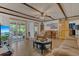 Cozy living room featuring wood-look floors, a sliding glass door to a screened porch and a beamed ceiling at 2990 E Central Ave, Bartow, FL 33830