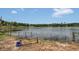 Lakeside view featuring a grassy shoreline, wooden dock, and peaceful water at 2990 E Central Ave, Bartow, FL 33830