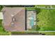 Aerial view of the backyard showcasing a screened pool and spa, complemented by lush greenery at 3009 Park Ridge Ave, Mulberry, FL 33860
