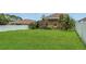 Expansive backyard with green grass, fencing, and tropical foliage at 3009 Park Ridge Ave, Mulberry, FL 33860