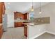 Open kitchen with tile floors, breakfast bar, stainless steel refrigerator and wood cabinets at 3009 Park Ridge Ave, Mulberry, FL 33860