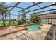 Inviting screened-in pool with attached spa and lush greenery at 3009 Park Ridge Ave, Mulberry, FL 33860