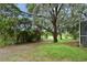 The spacious backyard features lush grass, mature trees draped with Spanish moss, enhancing its natural, serene beauty at 33042 Lake Bend Cir, Leesburg, FL 34788