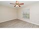 An empty bedroom features hardwood floors and a window with blinds at 33042 Lake Bend Cir, Leesburg, FL 34788