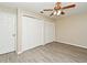 Bedroom with wood-look flooring, ceiling fan, double closets for storage, and a bright window at 33042 Lake Bend Cir, Leesburg, FL 34788