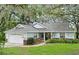 Charming single-story home with attached garage and lush landscaping at 33042 Lake Bend Cir, Leesburg, FL 34788