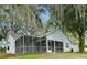 Back exterior of house features a screened-in patio and lush greenery at 33042 Lake Bend Cir, Leesburg, FL 34788