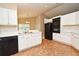 Efficient kitchen with white cabinets, black appliances, and eat-in area at 33042 Lake Bend Cir, Leesburg, FL 34788