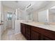 Bathroom featuring a double vanity, glass-enclosed shower, and neutral tile flooring at 3508 Brighton Park Cir, Belle Isle, FL 32812